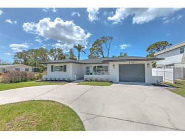 Charming single-story home with a well-manicured lawn and a spacious concrete driveway at 110 8Th St, Belleair Beach, FL 33786