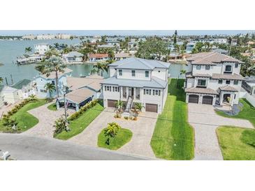 Stunning coastal home featuring a charming two-story design, beautiful landscaping, and a convenient two-car garage at 16025 Redington Dr, Redington Beach, FL 33708