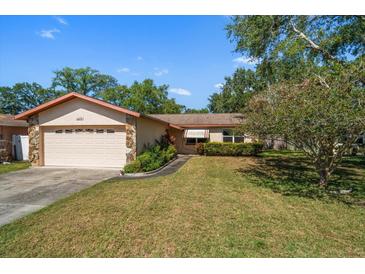 Charming single-story home featuring a well-manicured lawn and an attached two-car garage at 1632 St Catherine E Dr, Dunedin, FL 34698