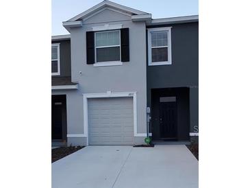 Charming two-story townhouse with a gray exterior and well-maintained front yard at 1853 Hovenweep Rd, Wesley Chapel, FL 33543