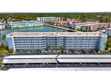 Exterior of building with parking lot and covered parking and view of other community buildings in the background at 5925 Shore S Blvd # 602, Gulfport, FL 33707