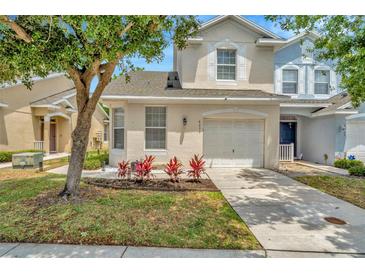 Charming two-story home featuring an attached garage and landscaped front yard at 6233 Olivedale Dr, Riverview, FL 33578