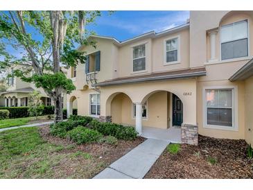 Charming two-story townhome featuring an inviting arched entryway, manicured landscaping, and a welcoming facade at 6842 Dartmouth Hill St, Riverview, FL 33578