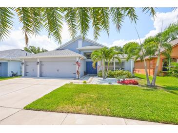 Charming home featuring well-manicured lawn, lush tropical landscaping and a three car garage at 7657 Nottinghill Sky Dr, Apollo Beach, FL 33572