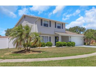 Charming two-story home features a well-manicured lawn, complemented by a blue door and a two-car garage at 3035 Annadale, Brandon, FL 33511