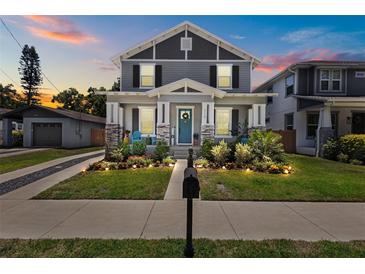 Charming two-story home with landscaped yard, cozy front porch and blue door at 710 W River Heights Ave, Tampa, FL 33603