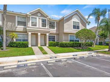 Inviting townhome exterior with lush landscaping, and designated visitor parking spaces at 732 Kensington Lake Cir, Brandon, FL 33511