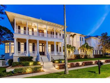 Elegant multi-story home with classic white columns, manicured landscaping, and inviting curb appeal at 755 Bay Esplanade, Clearwater Beach, FL 33767