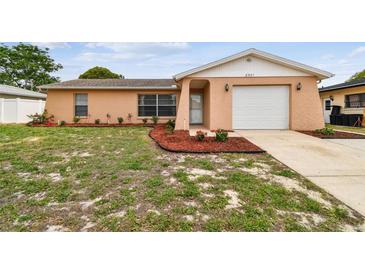 Charming single-story home featuring a well-manicured lawn and an attached one-car garage at 8531 Woodcrest Dr, Port Richey, FL 34668