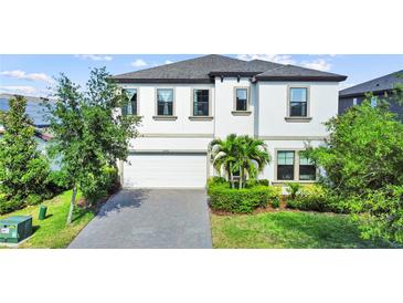 Charming two-story home featuring a well-maintained lawn, manicured landscaping, and a spacious two-car garage at 13130 Monach Isles Dr, Riverview, FL 33579