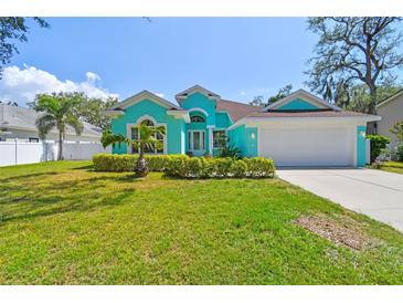 Charming home with a well-manicured lawn, lush landscaping, and a bright, inviting exterior at 1709 Sunset Dr, Tarpon Springs, FL 34689