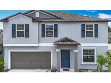 Charming two-story home featuring a gray exterior, two car garage, and a welcoming front entrance at 1876 Colding Dr, Ruskin, FL 33570