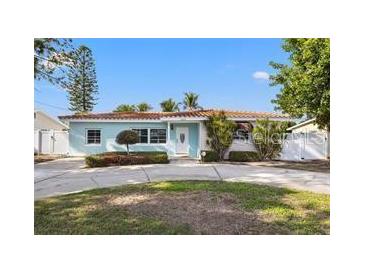 Charming single-story home boasts a classic style with well-maintained landscaping, a circular driveway, and a tiled roof at 3555 Belle Vista E Dr, St Pete Beach, FL 33706