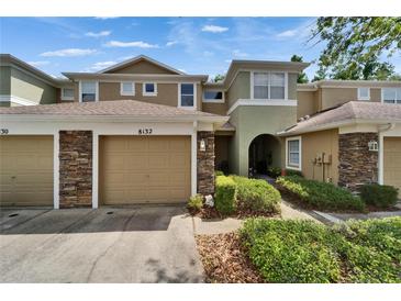 Inviting two-story townhome with stone accents, attached garage, and well-maintained landscaping at 8132 Stone Path Way, Tampa, FL 33647