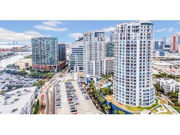 Stunning aerial view of luxury high-rise condominiums and a parking lot in an urban setting with blue skies at 1209 E Cumberland Ave # 2006, Tampa, FL 33602