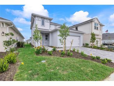 Charming two-story home with attached two-car garage, landscaped yard, and lovely gray exterior at 15918 Mulrion Blvd, Punta Gorda, FL 33982
