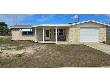 Charming single-story home featuring a unique stone facade and a cozy covered porch at 2035 Erin Dr, Holiday, FL 34690