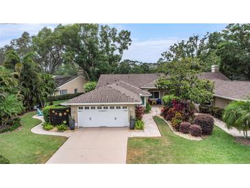 Charming home with mature landscaping and a two-car garage, creating excellent curb appeal at 3268 Tanglewood Trl, Palm Harbor, FL 34685