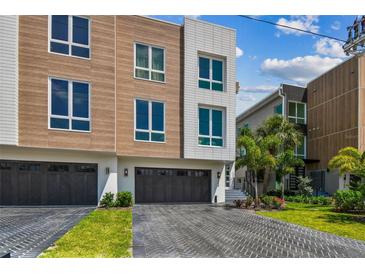 Striking multi-story home featuring a stylish mix of wood and white siding with a private two car garage at 344 Capri Blvd, Treasure Island, FL 33706