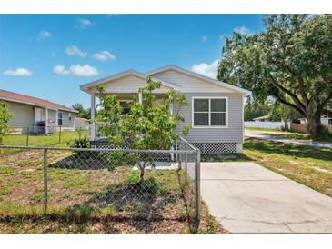 Charming single-story home featuring a fenced yard and inviting front porch, bathed in natural light on a sunny day at 3801 Carroway St, Tampa, FL 33619
