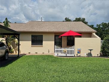 Charming single-story home with a well-manicured lawn and a cute, decorative white picket fence at 38225 Ironwood Pl # 38225, Zephyrhills, FL 33542