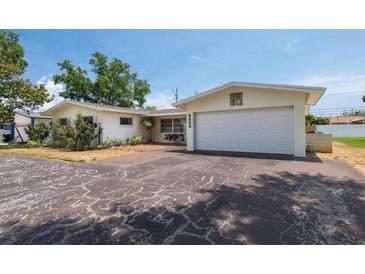 Charming single story home boasts a white garage door and a cracked dark driveway at 6638 12Th N Ter, St Petersburg, FL 33710