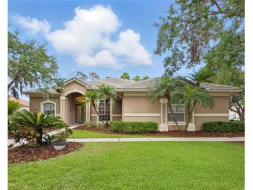 Charming single-story home with a tile roof, well-maintained landscaping, and lush green lawn at 10232 Estuary Dr, Tampa, FL 33647