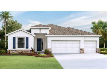 Stunning single-story home showcasing a three car garage, lush landscaping, and blue shutters with stone accents at 10652 Bridgegate Heights Loop, San Antonio, FL 33576