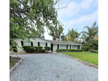 Charming single-story home with a gravel driveway and well-maintained landscaping at 1412 Sunset Ln, Lutz, FL 33549