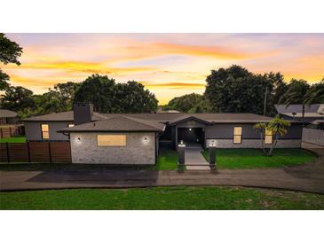 Charming single-story home with a well-manicured lawn and driveway at sunset at 2679 Haines Bayshore Rd, Clearwater, FL 33760