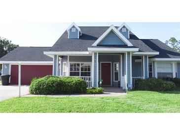 Charming home featuring a red garage door, dormer windows, a well-maintained lawn, and a welcoming front porch at 2797 Cordova S Way, St Petersburg, FL 33713