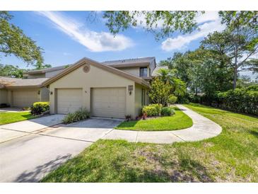 Charming home exterior with a two-car garage, well-maintained landscaping, and a walkway at 3066 Landmark Blvd # 1305, Palm Harbor, FL 34684