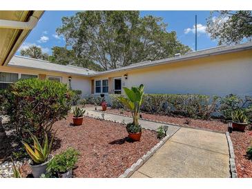Charming home entrance featuring a stone walkway, landscaped garden, and freshly mulched beds at 3122 37Th S Ln # C, St Petersburg, FL 33711