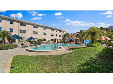 Outdoor pool with tanning chairs and green landscaping for a relaxed community feel at 6700 Sunset Way # 206, St Pete Beach, FL 33706