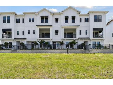 Stunning new construction featuring a modern, bright facade with balconies and professional landscaping at 7236 Sutton Ln, Sarasota, FL 34240