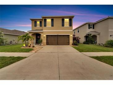 Inviting two-story home featuring a well-manicured lawn and a spacious driveway at 16815 Trite Bend St, Wimauma, FL 33598