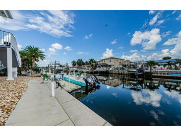 Scenic waterfront view featuring a private boat dock and canal access under a bright blue sky at 2186 Edythe Dr # 11, Dunedin, FL 34698