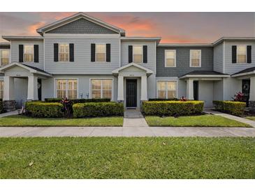 Charming townhome featuring a well-manicured lawn and inviting facade, perfect for modern living at 2432 Hearth Dr, Odessa, FL 33556