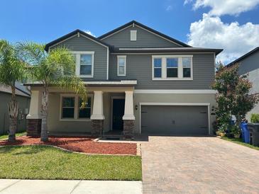 Charming two-story home with neutral gray siding, brick-paved driveway, and a well-manicured lawn at 6244 English Hollow Rd, Tampa, FL 33647