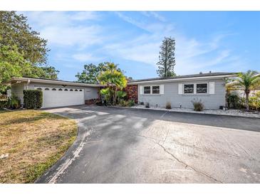 Charming single-story home featuring a well-maintained lawn, attached garage, and freshly painted exterior at 6811 N Himes Ave, Tampa, FL 33614