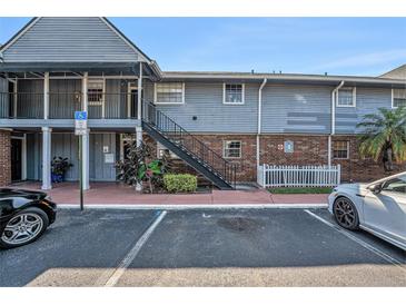Two-story condo building with blue siding, brick accents, and accessible parking at 200 Country Club Dr # 403, Largo, FL 33771
