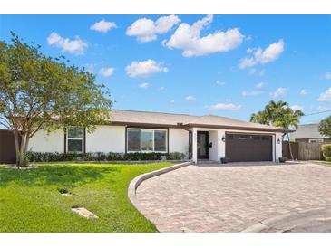 Charming one-story home with a well-manicured lawn and a brick driveway at 4331 13Th Ne Way, St Petersburg, FL 33703