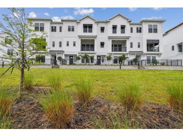Beautiful three-story townhomes with black metal railings and a well-manicured lawn at 7232 Sutton Ln, Sarasota, FL 34240