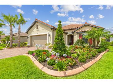 Charming home featuring a well-manicured lawn, colorful flower bed, and lush tropical landscaping at 4165 San Severo Rd, Wesley Chapel, FL 33543