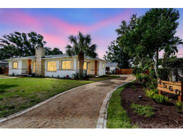 A well-maintained home with a stone chimney, garden beds and a gravel driveway at 4560 7Th N Ave, St Petersburg, FL 33713
