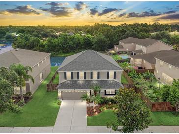 Two-story home boasts a manicured lawn, a two-car garage, and mature trees in a desirable community at 5804 Butterfield St, Riverview, FL 33578