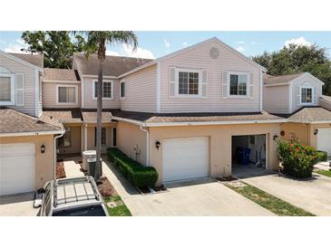 Exterior view of townhouse with attached garages, and well-maintained landscaping at 6980 Ulmerton Rd # 7C, Largo, FL 33771