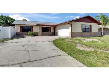Charming single-story home with a brick and siding exterior, attached garage, and curved driveway at 811 Pebblewood Dr, Brandon, FL 33511