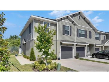 Stylish townhome featuring neutral siding, dark shutters, and attached single-car garage at 9665 Sweetwell Pl, Riverview, FL 33569