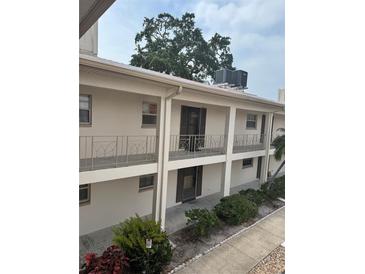 A two-story condo building featuring balconies and well-maintained landscaping at 19029 Us Highway 19 N # 2-23, Clearwater, FL 33764